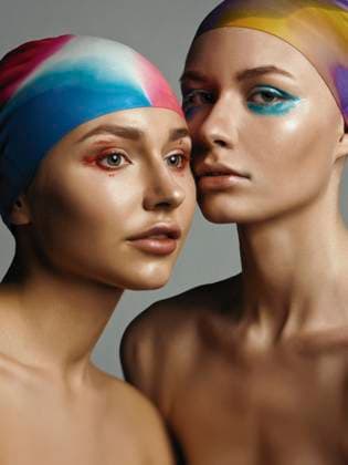 Creative Highlights Symbolbilder Young women wearing swimming caps against gray background model released, Symbolfoto, EKHF00095