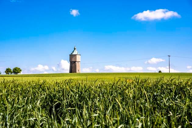 Germany, Baden-Wurttemberg, Crailsheim, Green springtime field with water tower in background, Baden-Wuerttemberg Deutschland EGBF00888