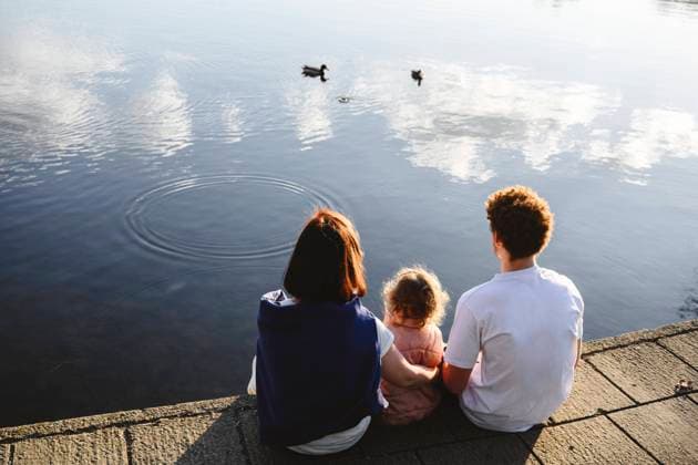 Family looking at ducks swimming in lake model released, Symbolfoto, EYAF02741