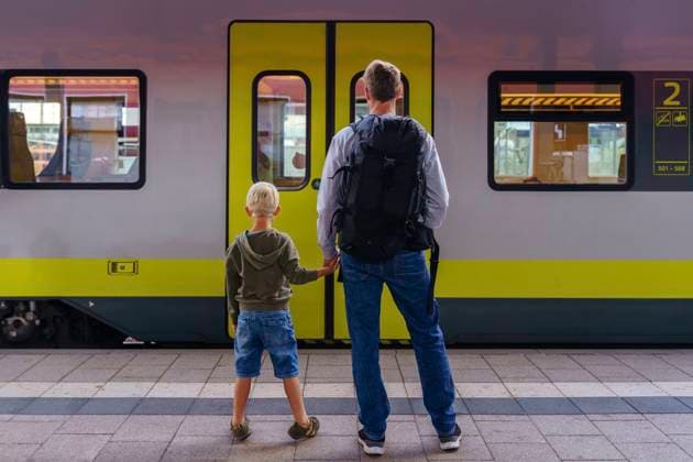 Father holding hands with son standing in front of train model released, Symbolfoto, NJAF00536