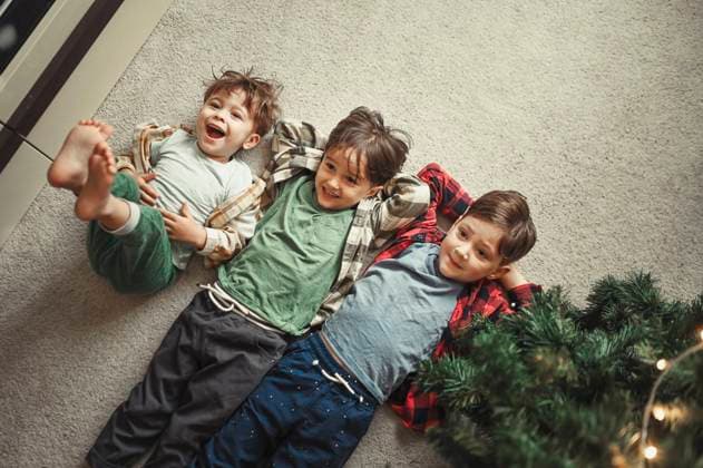 Brothers lying on carpet near Christmas tree at home model released, Symbolfoto property released, ANAF02095