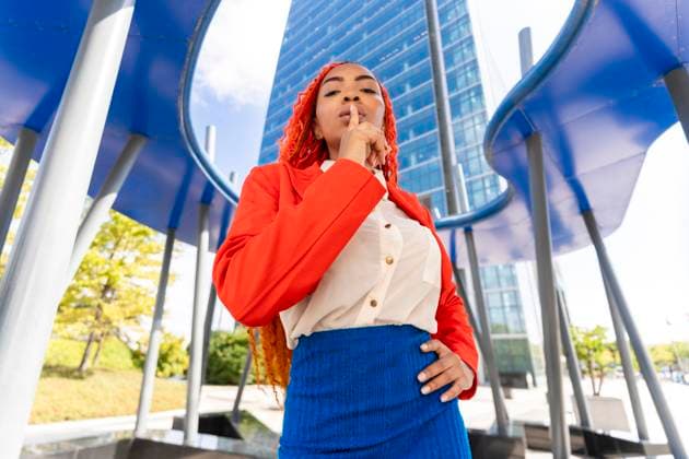 Creative Highlights Symbolbilder Businesswoman with finger on lips in office park model released, Symbolfoto, DLTSF03609