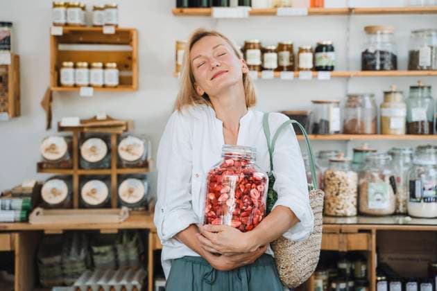 Smiling woman holding strawberries glass jar in shop model released, Symbolfoto property released, NDEF01083