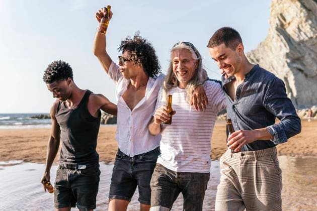 Cheerful multi-ethnic friends having beer and strolling at beach model released, Symbolfoto, PBTF00143