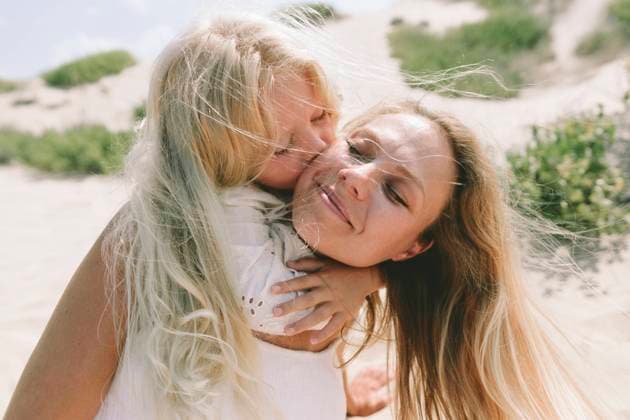 Loving daughter hugging and kissing mother on cheek at beach model released, Symbolfoto, SIF00828