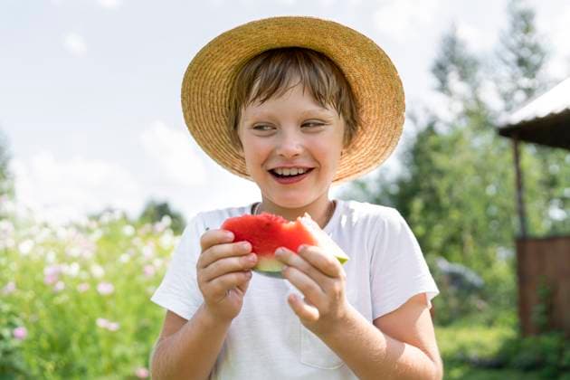 Creative Highlights Symbolbilder Smiling boy standing with slice of watermelon model released, Symbolfoto, VBUF00368