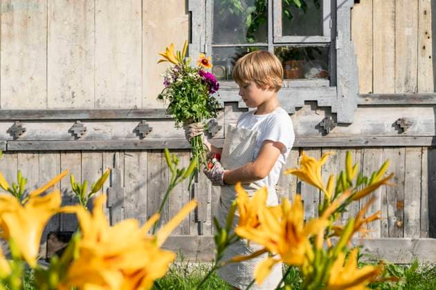 IMAGO Creative: Sommer, Sommertage im Garten Boy with bouquet of flowers standing in front of wooden house model released, Symbolfoto property released, VBUF00386