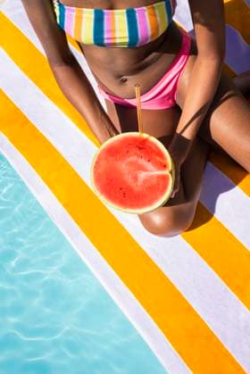 Young woman sitting with watermelon on sunny day model released, Symbolfoto, VRAF00183