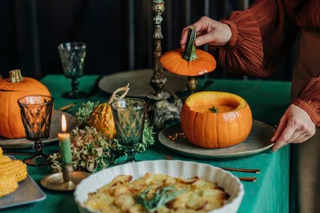 Woman serving pumpkin soup for thanksgiving dinner at dining table model released, Symbolfoto property released, VSNF01358