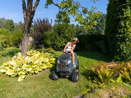  Frau fährt Rasenmäher, Rasentraktor, mit Strohhut und Sonnenbrille, im Garten bei der Arbeit, Deutschland, Europa *** Woman drives Lawn Mower, Lawn tractor, with Straw hat and Sunglasses, at Garden at the Work, Germany, Europe Copyright: imageBROKER/BerndxBieder iblbmb09659649.jpg ,model released, Symbolfoto ,property released