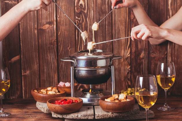 The cheese fondue Delicious Cheese Fondue on a fork on a wooden stand Copyright: xZoonar.com OksanaxShufrychx 11722448