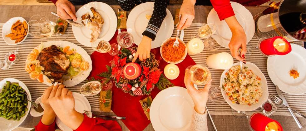 Christmas dinner table with beverages and appetizers Wide angle top view of holiday table with Christmas decoration. Roasted chicken with tangerines, vegetables, rice. Top view of hands of women and children, taking and cutting food ,model released, Symbolfoto Copyright: xZoonar.com OksanaxShufrychx 15003517 ,model released, Symbolfoto ,property released