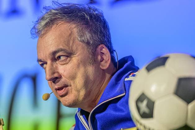 Zeiglers wunderbare Welt des Fußballs 27.09.2023, Uni Aula, Vechta, Zeiglers wunderbare Welt des Fußballs, Der Moderator strickt Fußballträume: Witzig, traurig, skurril und immer auch ein bisschen böse. Offen und unverblümt redet er in seinem Arbeitszimmer über Tragik, Tränen und Triumphe im Bild Arnd Zeigler (Moderator, ) an seinem Bühnenschreibtisch in der Aula der Uni Vechta vor ausverkauften Haus.
