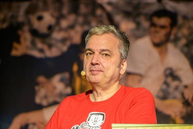 Zeiglers wunderbare Welt des Fußballs 27.09.2023, Uni Aula, Vechta, Zeiglers wunderbare Welt des Fußballs, Der Moderator strickt Fußballträume: Witzig, traurig, skurril und immer auch ein bisschen böse. Offen und unverblümt redet er in seinem Arbeitszimmer über Tragik, Tränen und Triumphe im Bild Arnd Zeigler (Moderator, ) an seinem Bühnenschreibtisch in der Aula der Uni Vechta vor ausverkauften Haus.