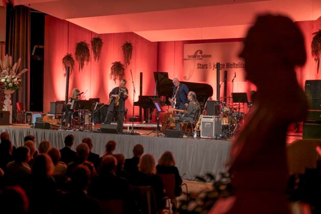 27.09.2023, Internationales Klassikfestival: Festival der Nationen 2023, im Kurhaus Bad Wörishofen im Unterallgäu, Der britische Violinist Nigel Kennedy & friends, Kennedy auf der Bühne, die Büste von Pfarrer Sebastian Kneipp steht am Rand 27.09.2023, Klassikfestival Bad Wörishofen 27.09.2023, Klassikfestival Bad Wörishofen