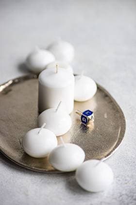 Ivory colored scented candles with blue Hanukkah dreidel placed on plate From above of celebration of Jewish light festival with ivory colored scented candles blue Hanukkah dreidel and cute spinning top on plate in daylight Model Released AnnaBogush_ID16595_504445_002 Copyright: xAnnaxBogushx