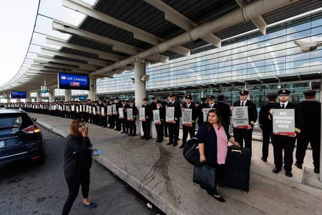 September 29, 2023, TORONTO, ON, Canada: Travellers walk by a demonstration of Air Canada pilots outside Pearson International Airport in Toronto, as their union is calling for an updated contract for the pilots, Friday, Sept. 29, 2023. TORONTO Canada  - ZUMAc35_ 20230929_zaf_c35_032 Copyright: xColexBurstonx