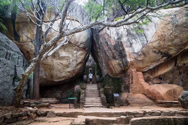 Tourists walking on stairs between two huge stones in Sigiriya, Sri Lanka Sigiriya, Sri Lanka - 23 March 2017: Tourists walking on stairs between two huge orange stones Copyright: xZoonar.com LoesxKieboomx 15676408