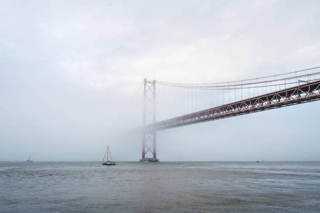 Blick auf die Brücke 25 de Abril, das berühmte touristische Wahrzeichen Lissabons, die Lisboa und Almada verbindet, im dichten Nebel mit darunter durchfahrenden Booten. Lissabon, Portugal, Europa *** View at the Bridge 25 de Abril, the famous tourist Landmark Lisbons, the Lisboa and Almada connects, at seal Fog with including durchfahrenden Boating Lisbon, Portugal, Europe Copyright: imageBROKER DmitryxRukhlenko ibxdmr09639949.jpg