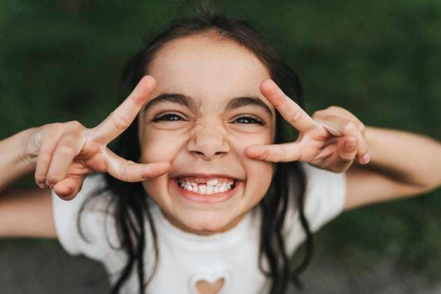 Creative Highlights Symbolbilder Portrait of happy elementary girl showing peace sign at park Sweden, Gothenburg, model released Copyright: xMaskotx , MA103993 MA103993