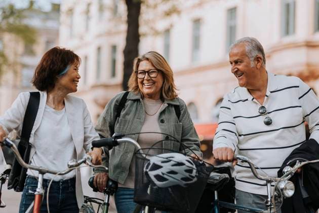 Happy male and female senior friends with bicycles on footpath Sweden, Stockholm, model released Copyright: xMaskotx , MA103862 MA103862
