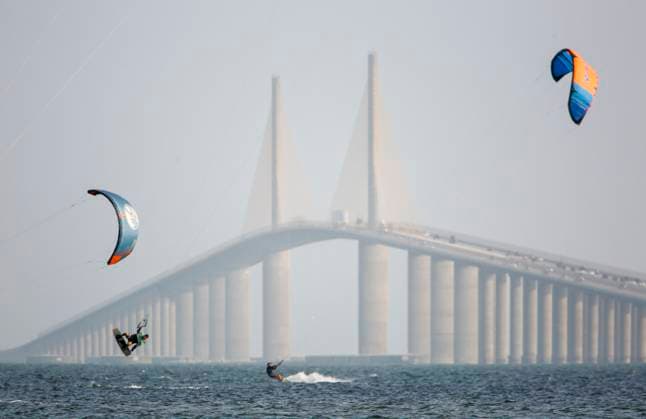 October 3, 2023, St. Petersburg, Florida, USA: Windsurfers glide through a smokey haze as it falls over the Sunshine Skyway Bridge on Tuesday, Oct 3, 2023, in St. Petersburg where smoke from a Canadian wildfire ended up in Florida due to winds from a combination of a low-pressure system and a high-pressure system over the eastern U.S., which has carries the smoke as far south as Miami. St. Petersburg USA - ZUMAs70_ 20231003_zan_s70_104 Copyright: xDouglasxR.xCliffordx
