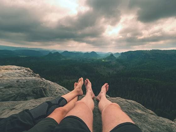 Tired hikers legs without shoes in mountains. Barefoot legs Tired hikers legs without shoes in mountains. Barefoot legs of heterosexual couple. Long forest valley in hilly landscae of nature park. ,model released, Symbolfoto Copyright: xZoonar.com rdonarx 20483122 ,model released, Symbolfoto ,property released