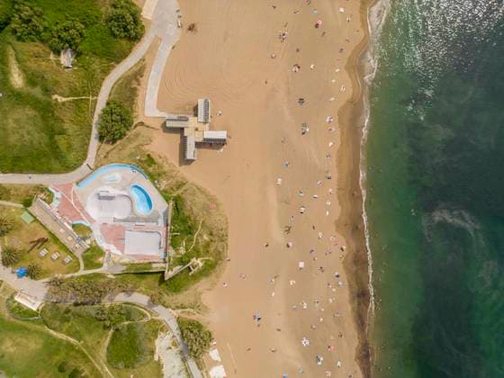 Creative Highlights Symbolbilder Drone view of resort beach in Mediterranean sea Aerial top view of resort hotel poolside and beach area with people sunbathing in Menorca island Model Released JuanAizpuru_ID16312_496476_001 Copyright: xJuanxAizpurux