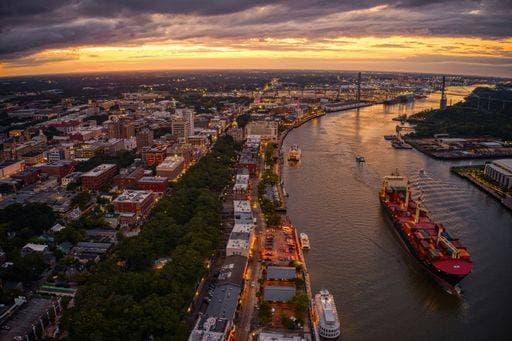 An aerial view of dense buildings and a river in Downtown Savannah, Georgia at sunset 3307008 RECORD DATE NOT STATED