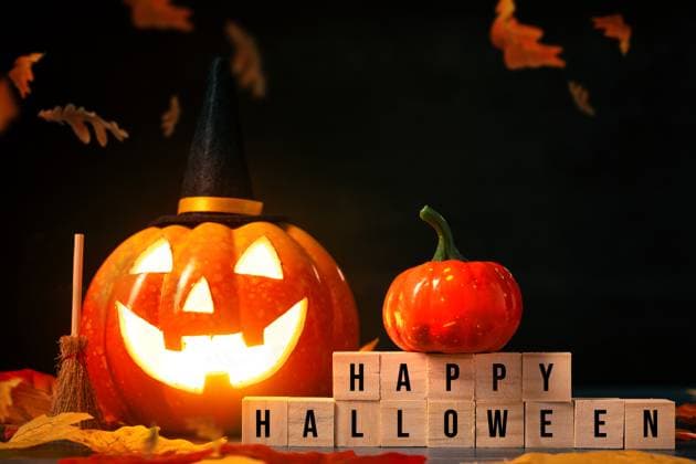 Augsburg, Bavaria, Germany - 5 October 2023: Greeting to Halloween, glowing carved pumpkin with witch hat and wooden cube with inscription: Happy Halloween PHOTOMONTAGE *** Gruß zu Halloween, leuchtender geschnitzer Kürbis mit Hexenhut und Holzwürfel mit Aufschrift: Happy Halloween FOTOMONTAGE