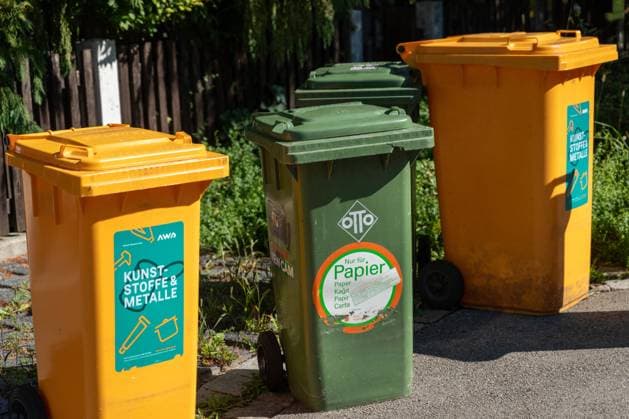 Augsburg, Bavaria, Germany - 7 September 2023: Garbage garbage cans for garbage collection on the street in front of a residential building. Waste separation and recycling concept *** Mülltonnen für die Müllabfuhr auf der Straße vor einem Wohnhaus. Mülltrennung und Recycling Konzept