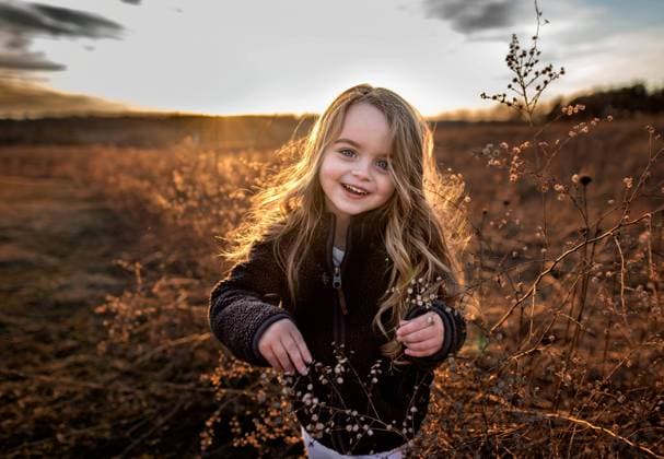 Creative Highlights Symbolbilder Happy young girl smiling in field of flowers in fall Wooster, Ohio, United States CR_JOKU231007-1203318-01 ,model released, Symbolfoto
