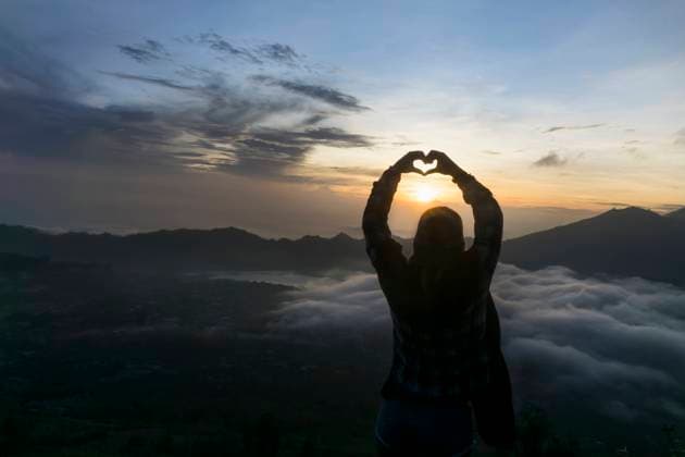 Creative Highlights Symbolbilder Silhouette of a young woman fingers forming a heart at dawn, Uluwatu, Bali, Indonesia Munich, Munich, Germany CR_RONI160607-01803-01 ,model released, Symbolfoto