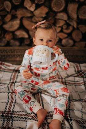 Little girl in holiday PJs sips from a Santa mug Billings, Montana, United States R_BAEK231005-1254628-01 ,model released, Symbolfoto