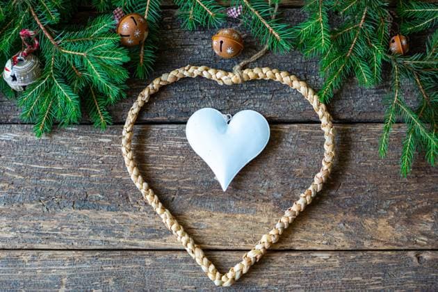 16 August 2023: Christmas decoration, heart on wood background with green fir branches *** Weihnachtsdekoration, Herz auf Holz Hintergrund mit grünen Tannenzweigen