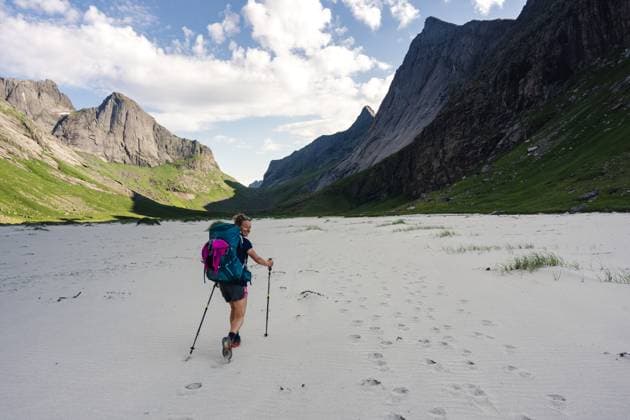Creative Highlights Symbolbilder Woman hiking on beach below large mountains Kirkefjord, Nordland, Norway CR_XSCA231012-1267680-01 ,model released, Symbolfoto