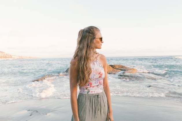 Creative Highlights Symbolbilder woman in sunglasses and floral top standing in fron of blue wate Laguna Beach, California, United States R_YFEU2204259C-968322-01 ,model released, Symbolfoto