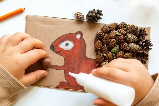 7 October 2023: Children s fun with autumn leaves: creative crafts at home. A child crafts a squirrel that he painted himself and then attached pine cones with glue *** Kinderspaß mit Herbstlaub: Kreatives Basteln zu Hause. Ein Kind bastelt ein Eichhörnchen das es selbst gemalt hat und anschließend Tannenzapfen mit Kleber befestigt