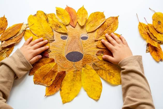 7 October 2023: Children s fun with autumn leaves: creative crafts at home. A child makes a lion from leaves and cardboard *** Kinderspaß mit Herbstlaub: Kreatives Basteln zu Hause. Ein Kind bastelt einen Löwen aus Blättern und Pappe