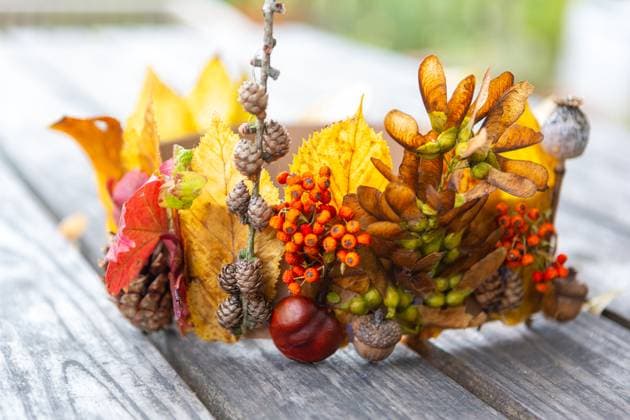 7 October 2023: Children s fun with autumn leaves: creative crafts in autumn. Homemade crown from colorful leaves, acorns and berries *** Kinderspaß mit Herbstlaub: Kreatives Basteln im Herbst. Selbstgemachte Krone aus bunten Blättern, Eicheln und Beeren