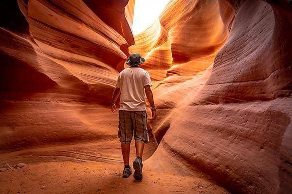 Creative Highlights Symbolbilder Page, Arizona United States, August 2019: Ein junger Tourist mit weißem Hemd läuft in Lower Antelope *** Page, Arizona United States, August 2019 a Youngster Tourist with white Shirt running in Lower Antelope Copyright: imageBROKER/UnaixHuizi ibxuhu09741786.jpg ,model released, Symbolfoto ,property released