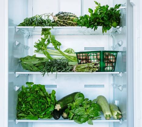 Green vegetables and greens in open refrigerator Fresh green vegetables in household refrigerator. Open full refrigerator with selected green vegetables and greens - cabbages, zucchini, basil, avocado, cucumbers. Vegetarian healthy food Copyright: xZoonar.com OlgaxSergeevax 20553700