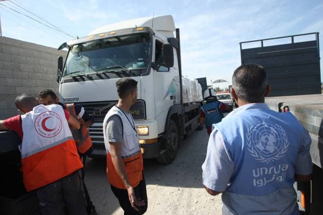 Workers from the Palestinian Red Crescent and UNRWA arrive to unload lorries carrying humanitarian aid after they entered the Gaza Strip from Egypt via the Rafah border crossing, on Saturday, October 21, 2023. 20 trucks carrying humanitarian aid entered the war-torn and besieged Gaza Strip on October 21 through the Rafah border crossing with Egypt.  GAZ2023102106 IsmaelxMohamad