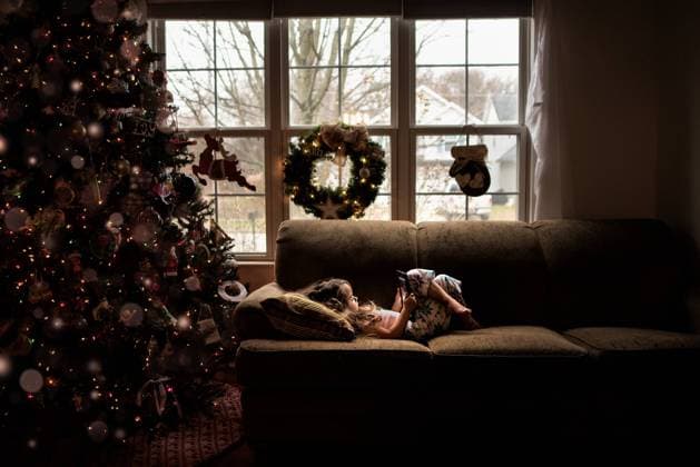 Little girl laying on the couch playing with technology at Christmas Wooster, Ohio, United States CR_JOKU231018-1269852-01 ,model released, Symbolfoto
