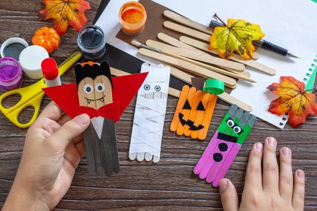 Child is holding Halloween ghost and vampire toy gift stics puppets on wooden table. Handmade. Project of children s creativity, handicrafts, crafts for kids. Child is holding Halloween ghost and vampire toy gift stics puppets on wooden table. Handmade. Project of children s creativity, handicrafts, crafts for kids. Copyright: xZoonar.com KHRAMOVAxxELENAx 20597906