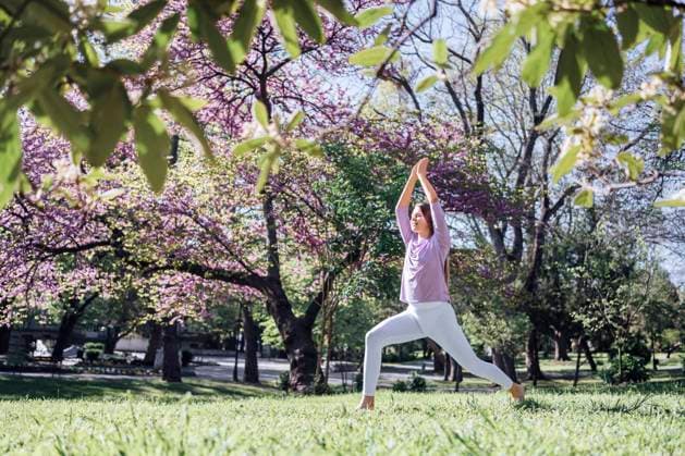 IMAGO Creative, Jahreszeit Frühling, Licht und Sonne Teenage girl practicing yoga at park in bloom model released, Symbolfoto, AAZF00729