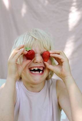 Playful girl covering eyes with fresh strawberries from garden model released, Symbolfoto, Hamburg Hamburg Deutschland Altes Land GISF00963