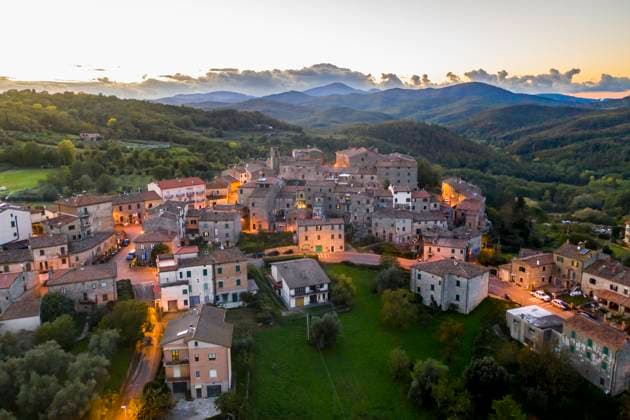 Italy, Tuscany, Torniella, Aerial view of mountain village at dusk, AMF09930
