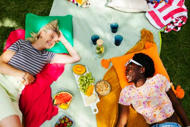 Smiling friends lying on picnic blanket in garden model released, Symbolfoto, EBSF03759