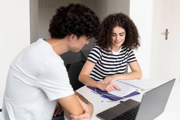 Tschechien, Hochschule streicht wegen KI und Plagiate Bachelorarbeiten Young student explaining friend at table in university model released, Symbolfoto, LMCF00628